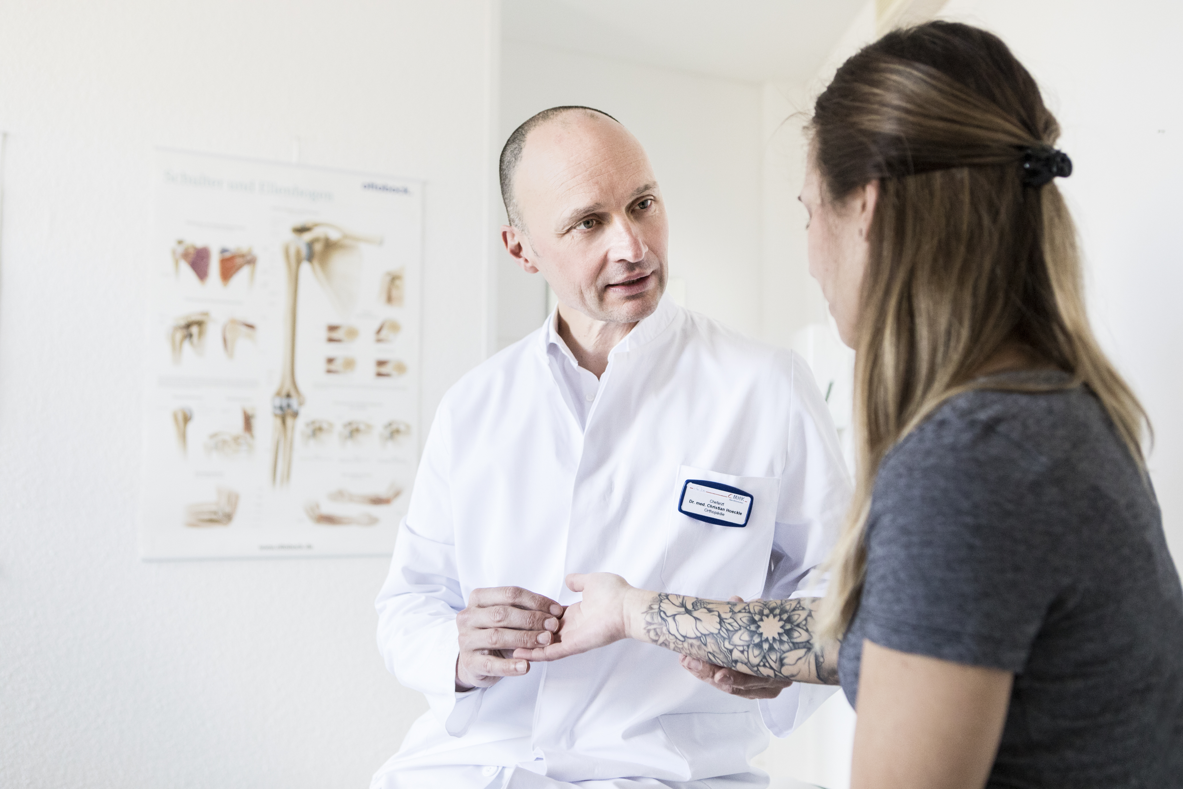 Ein Orthopäde führt ein Gespräch mit einer Patientin