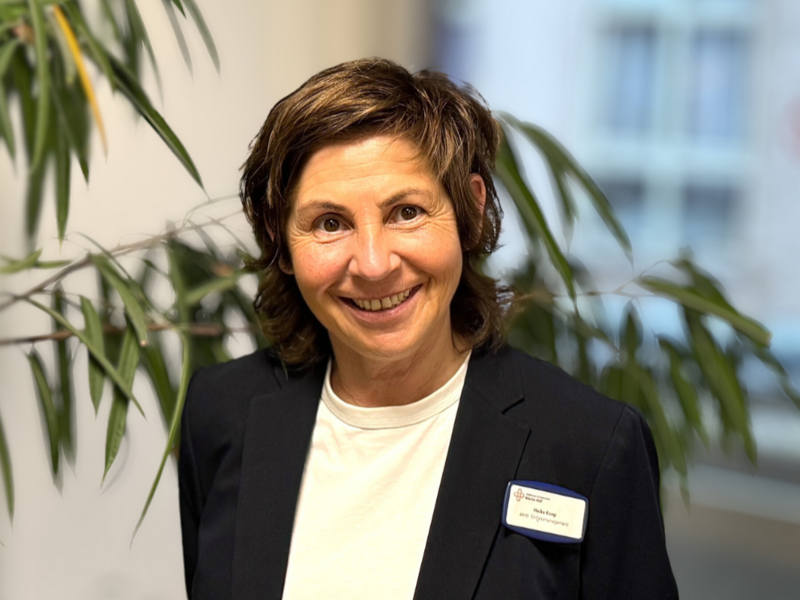 Porträt einer Frau mit kurzen braunen Haaren, weißem Shirt und schwarzem Blazer