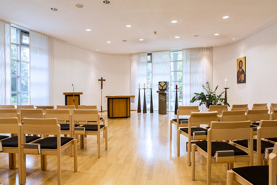 Ein heller bestuhlter Raum, der mit Altar vorne in der Mitte als Krankenhaus-Kapelle dient