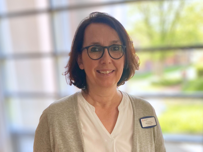 Porträt einer Frau mit schwarzen Haaren und Brille